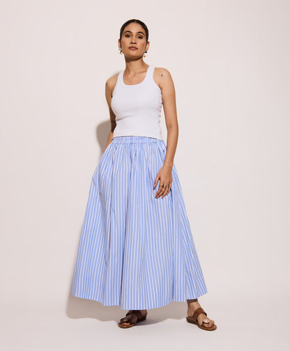 Woman wearing a white tank top and light blue striped skirt